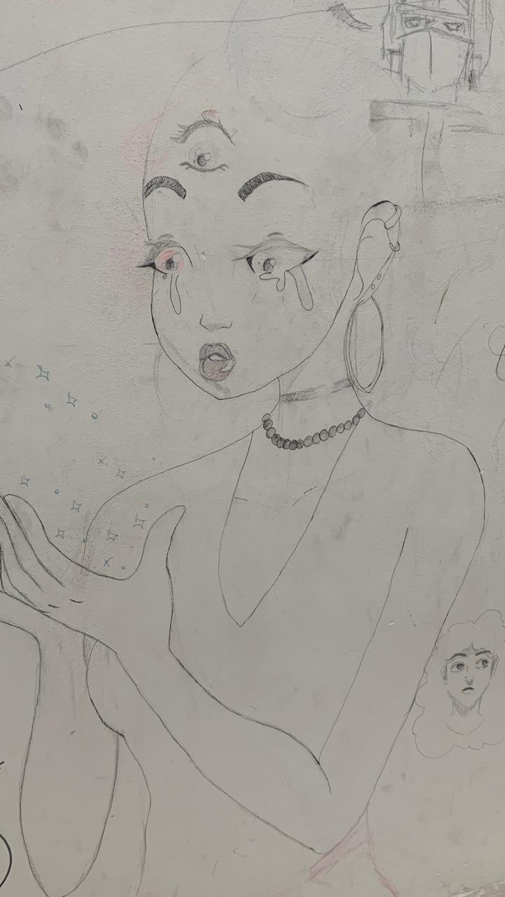Desenho feito a lápis e caneta em uma parede branca. O desenho principal é o busto de uma figura feminina estilizada, com um terceiro olho na testa e grandes olhos expressivos, com lágrimas caindo de cada um. A figura tem a cabeça raspada, veste um decote em V e usa um colar e um grande brinco de argola. Ela estende as mãos abertas para a frente, com pequenos símbolos de estrelas e brilhos desenhados ao redor, sugerindo magia ou poder.