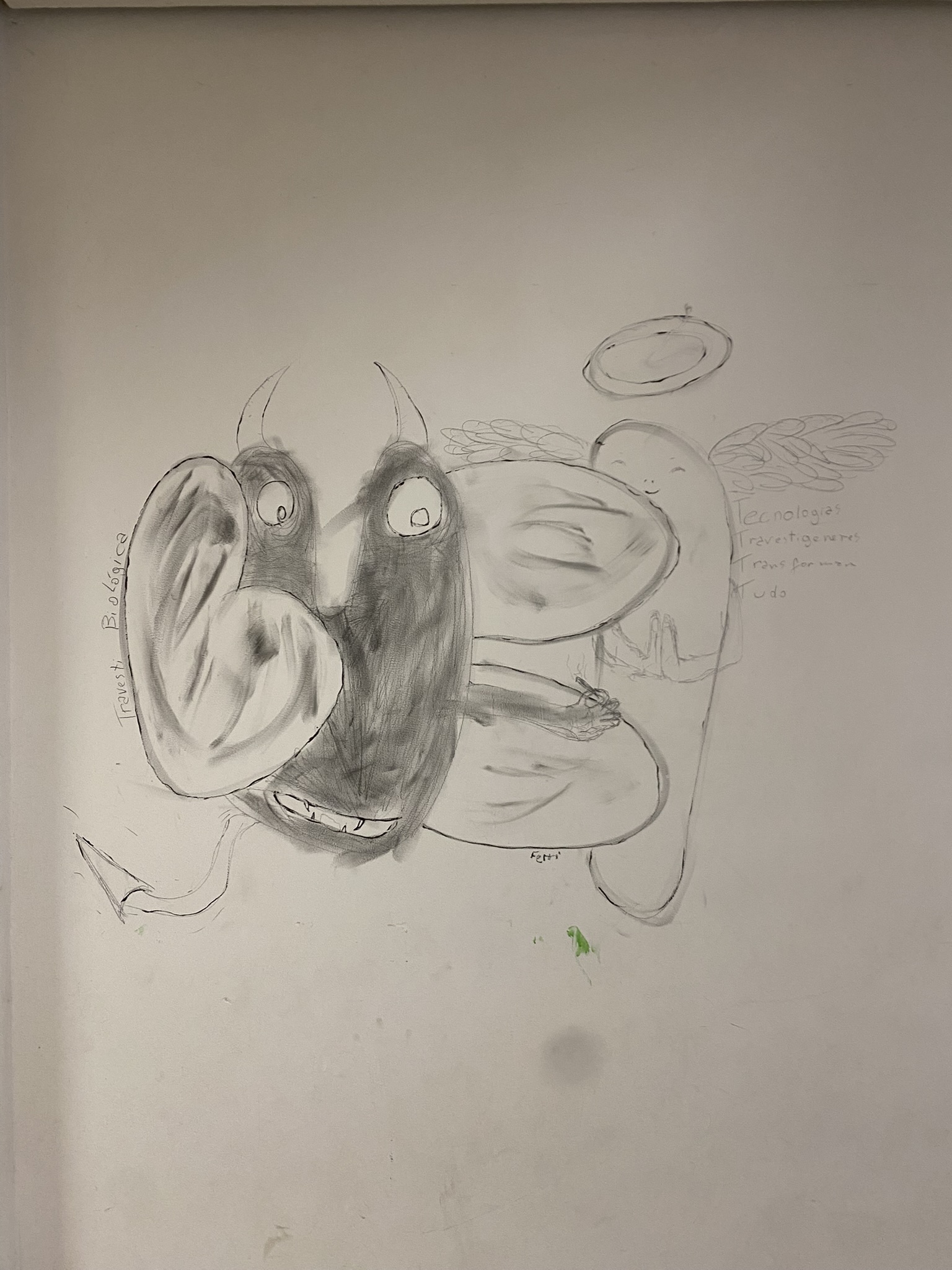 Desenho em lápis e carvão em uma parede branca. A composição central mostra um demônio e um anjo abraçados. O demônio, em preto e cinza com sombreamento pesado, tem chifres, dentes visíveis em um sorriso largo, e uma cauda. O anjo, desenhado em linha clara e com asas e auréola, está à direita. O desenho sugere um abraço ou fusão das duas figuras. No lado direito, há um texto escrito a lápis que menciona "Tecnologias Travestigeneres Transformam Tudo".
