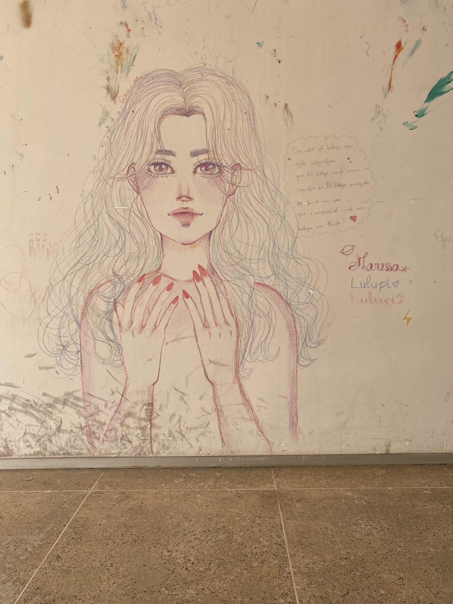 A imagem exibe a pintura de uma figura feminina com longos cabelos ondulados e olhos grandes em tons rosados, feita com traços leves de lápis de cor sobre uma parede. Ao lado da figura, há um balão de fala com o texto: "Se você vê beleza aqui não significa que há beleza em mim significa que há beleza enraizada em fundo em você que é impossível não ver beleza em tudo!