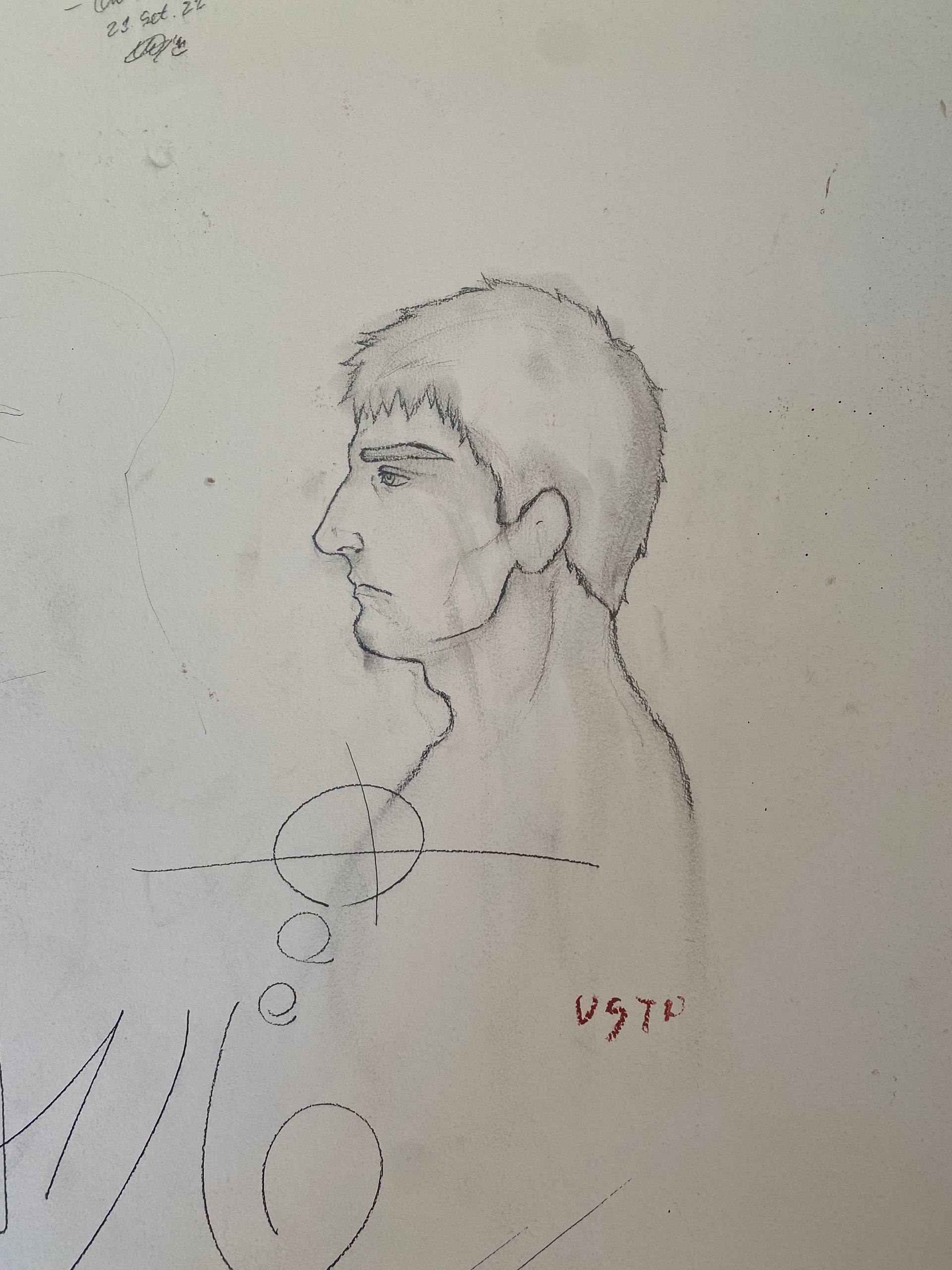 A imagem apresenta o perfil de um homem desenhado a lápis sobre uma parede branca. O desenho foca na cabeça e pescoço, mostrando cabelos curtos e espetados, sobrancelhas marcadas e uma expressão séria. Abaixo do queixo do homem, há um símbolo geométrico composto por um círculo atravessado por uma linha horizontal e outras formas abstratas.